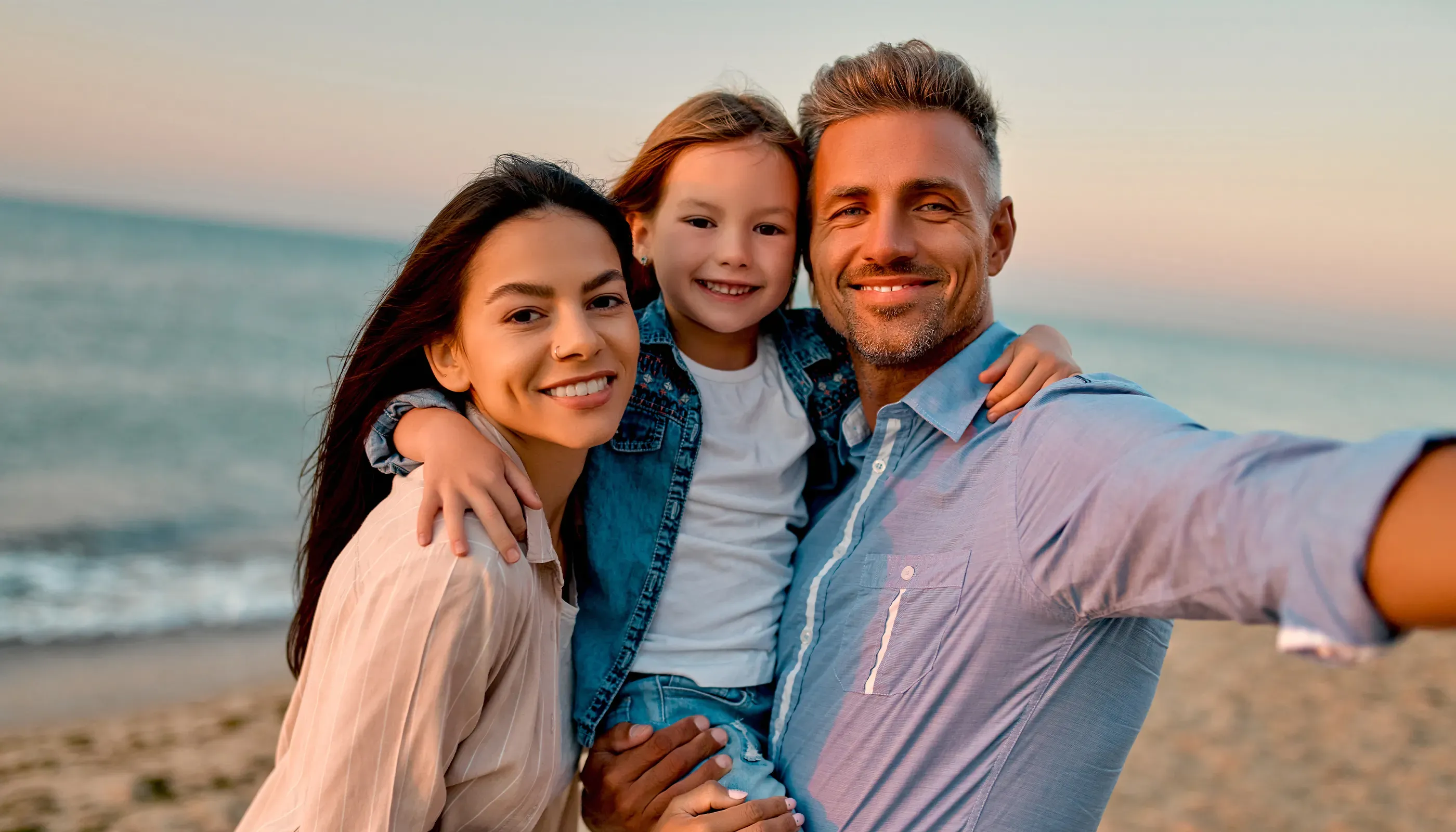 young family smiling on the beach